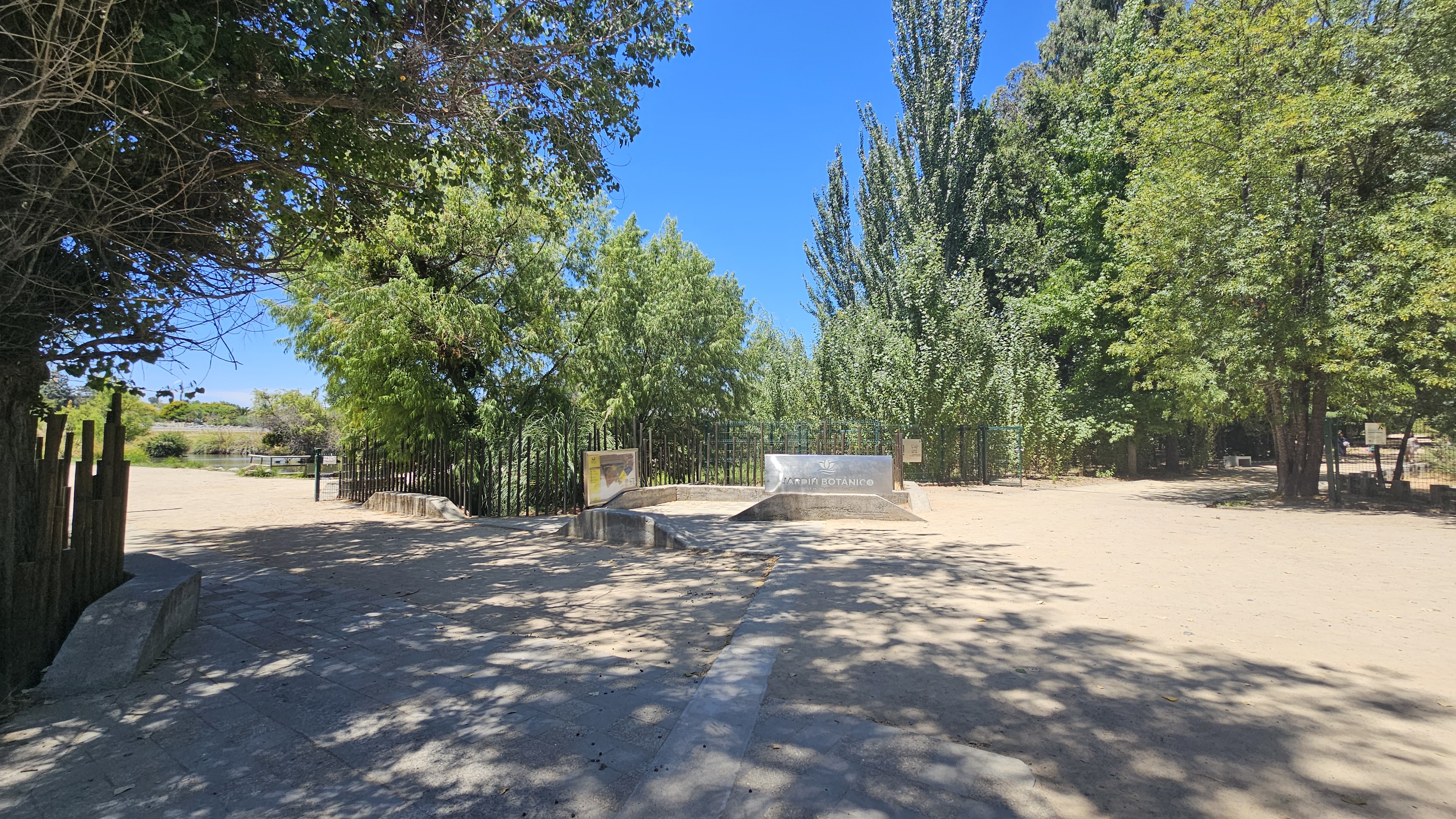 Fotografía de un sector con bancas de concreto y sombra